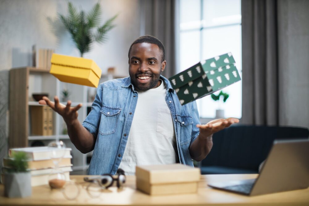 African influencer taking fun while unpacking gift boxes